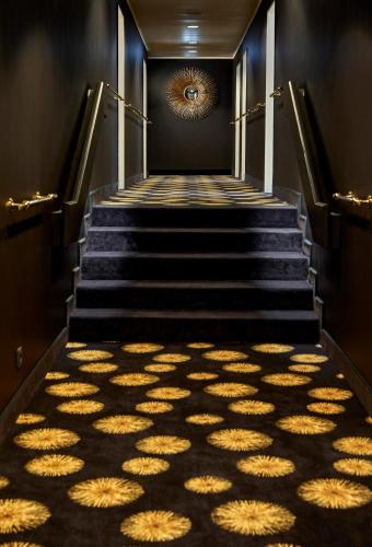 a set of stairs with a light shining on the floor at Das Carls Hotel in Düsseldorf