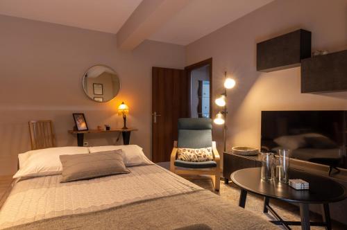 sypialnia z łóżkiem, krzesłem i kominkiem w obiekcie Eleni's modern apartment w mieście Wolos