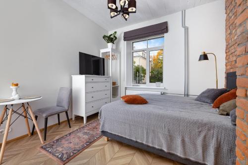 1 dormitorio con cama, mesa y ventana en Peetri Apartments, en Tartu