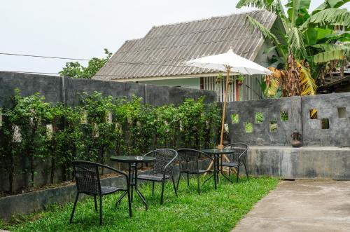 a table and chairs with an umbrella in the grass at Namu Hotel in Pai