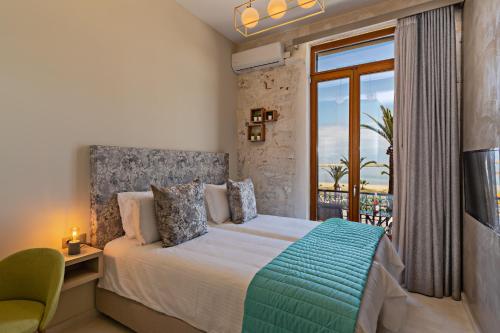 1 dormitorio con cama y ventana grande en Mitos-Suites en Rethymno Town