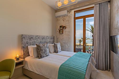 a bedroom with a bed and a large window at Mitos-Suites in Rethymno Town