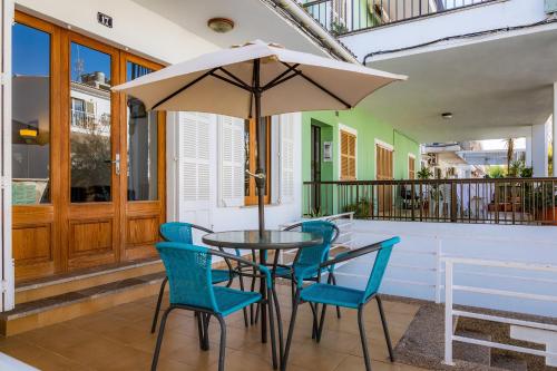 - une table avec des chaises et un parasol sur une terrasse couverte dans l'établissement Can Miquel, à Can Picafort