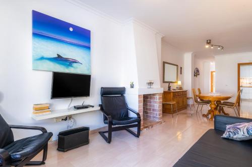un salon avec une télévision à écran plat au mur dans l'établissement Can Miquel, à Can Picafort