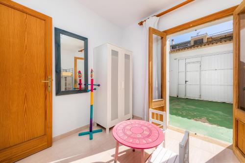 Cette chambre comprend une porte, une table et une fenêtre. dans l'établissement Can Miquel, à Can Picafort
