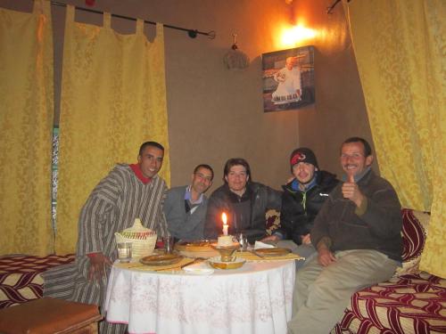 a group of men sitting around a table with a cake at Kasbah Maison D’hôte Lalla Zahra in Aït Baha