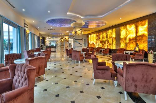 a restaurant with tables and chairs in a lobby at Crystal Waterworld Resort & Spa - Ultimate All Inclusive in Belek