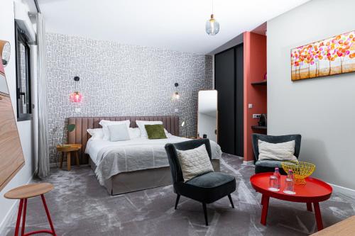 pokój hotelowy z łóżkiem, stołem i krzesłami w obiekcie En Marge w mieście Aureville