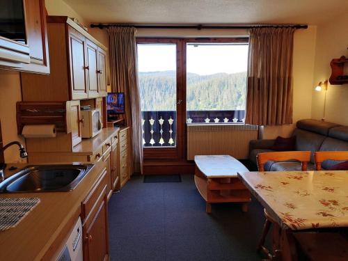 une cuisine avec un évier, une table et une fenêtre dans l'établissement Studio cabine fonctionnel pour 6 pers. au pied des pistes - Parking inclus - FR-1-595-5, à Notre-Dame-de-Bellecombe