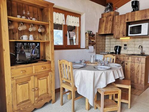 une cuisine avec une table et des chaises dans une cuisine dans l'établissement Studio/Cabine avec Mezzanine - Proche Pistes, 5 Pers. - FR-1-595-17, à Notre-Dame-de-Bellecombe
