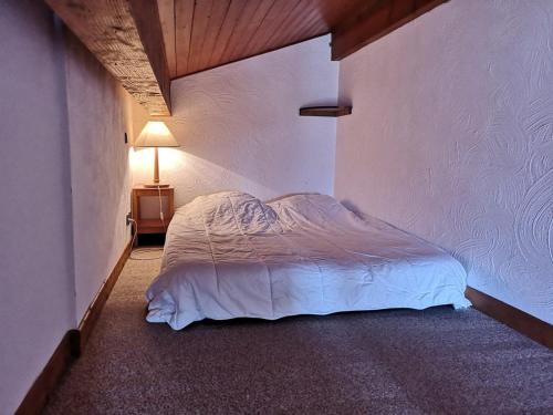 - une chambre avec un lit et une lampe dans l'établissement Studio/Cabine avec Mezzanine - Proche Pistes, 5 Pers. - FR-1-595-17, à Notre-Dame-de-Bellecombe