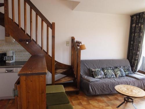 un salon avec un canapé et un escalier dans l'établissement Duplex 2 pièces à Notre-Dame-de-Bellecombe, au calme proche des pistes - pour 6 personnes - FR-1-595-20, à Notre-Dame-de-Bellecombe