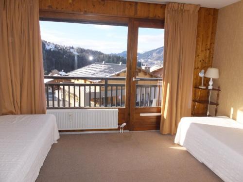 une chambre avec deux lits et une grande fenêtre dans l'établissement Duplex 2 pièces à Notre-Dame-de-Bellecombe, au calme proche des pistes - pour 6 personnes - FR-1-595-20, à Notre-Dame-de-Bellecombe
