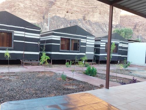 a house with black and white stripes on it at Wadi Rum Oryx Hostel & Tours in Wadi Rum