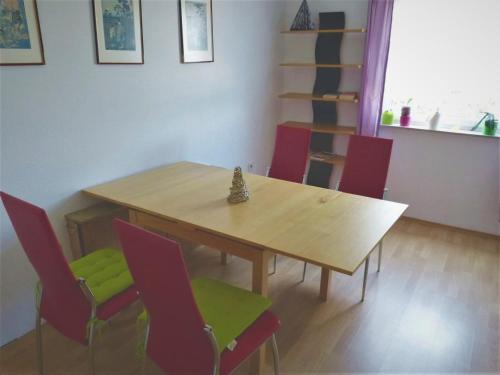 comedor con mesa de madera y sillas rojas en Gästezimmer Gross en Tübingen