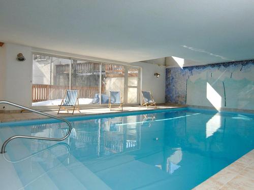 - une piscine avec 2 chaises et une fenêtre dans l'établissement Charmant T2 cabine avec piscine à Notre-Dame-de-Bellecombe - 6 pers, proche pistes & commerces - FR-1-595-23, à Notre-Dame-de-Bellecombe