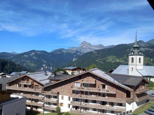 un grand bâtiment avec une église et une montagne dans l'établissement Studio ensoleillé à Notre-Dame-de-Bellecombe, proche pistes, balcon, parking, casier à ski, 4 pers. - FR-1-595-28, à Notre-Dame-de-Bellecombe