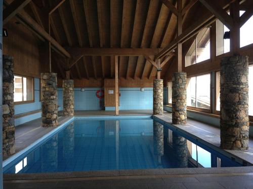 une grande piscine intérieure avec un plafond en bois dans l'établissement Appartement 3 Pièces avec Piscine et Parking - Les Saisies, 7 pers - FR-1-594-75, à Villard-sur-Doron