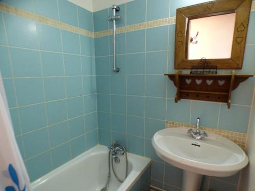 une salle de bain carrelée bleue avec un lavabo et une baignoire dans l'établissement Studio Cabine Mezzanine aux Saisies - Centre Station, Balcon Sud, 4 Pers, 2 étoiles - FR-1-594-100, à Hauteluce