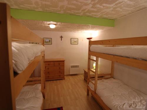 Cette chambre comprend 2 lits superposés et une croix sur le mur. dans l'établissement Duplex convivial 8 pers, 3 pièces - Les Saisies - FR-1-594-182, à Hauteluce