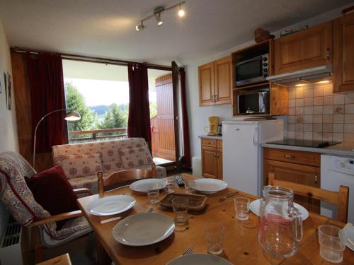 une cuisine avec une table avec des assiettes et des verres dessus dans l'établissement Duplex convivial 8 pers, 3 pièces - Les Saisies - FR-1-594-182, à Hauteluce