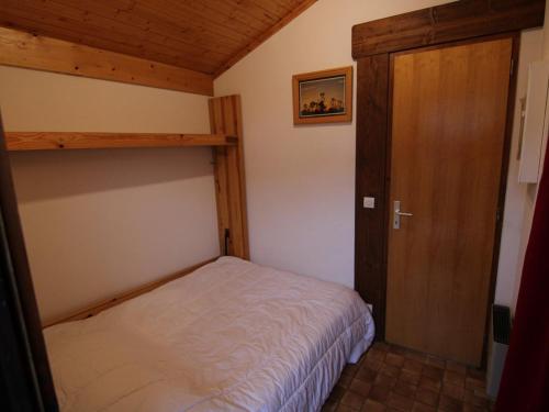 une petite chambre avec un lit et une porte en bois dans l'établissement Studio cabine aux Saisies, 4 personnes, proche commerces et pistes - FR-1-594-151, à Hauteluce
