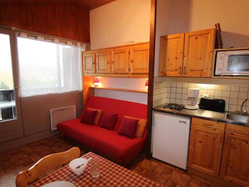 un salon avec un canapé rouge dans une cuisine dans l'établissement Studio cabine aux Saisies, 4 personnes, proche commerces et pistes - FR-1-594-151, à Hauteluce