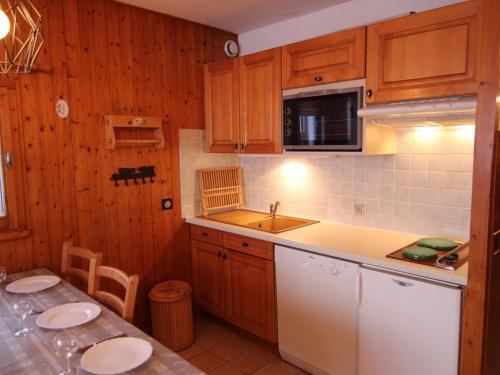une cuisine avec des armoires en bois et un comptoir dans l'établissement Studio Alcôve Cabine 6 Pers, Balcon & Wifi - Les Saisies - FR-1-594-200, à Hauteluce