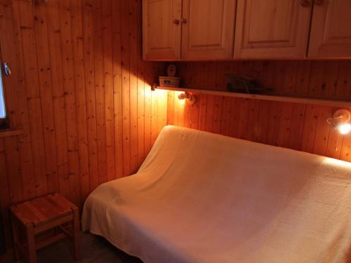 une chambre avec un lit blanc et un mur en bois dans l'établissement Studio Alcôve Cabine 6 Pers, Balcon & Wifi - Les Saisies - FR-1-594-200, à Hauteluce