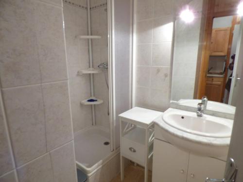 une salle de bain blanche avec une douche et un lavabo dans l'établissement Studio confortable aux Saisies pour 4 personnes avec balcon et cuisine équipée - FR-1-594-127, à Hauteluce
