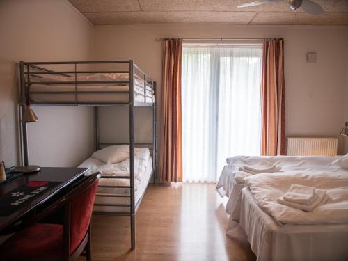 a bedroom with two bunk beds and a desk at Hotel Søgården Brørup in Brørup