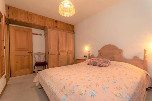 Schlafzimmer mit einem Bett und einem Kronleuchter in der Unterkunft Ciasa Molino 306 in Falcade