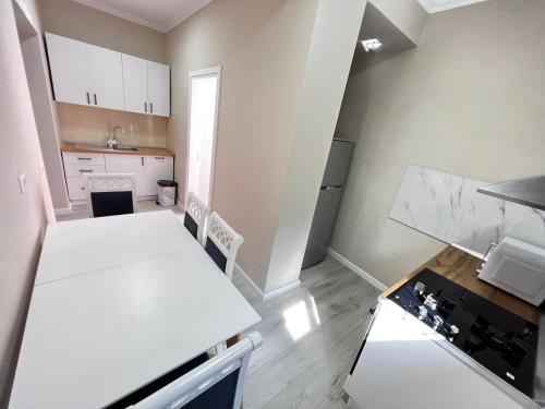 Una cocina con una mesa blanca y una estufa. en Golden Cherry, en Tirana