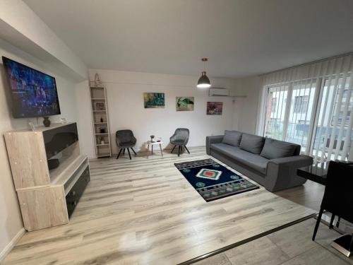 a living room with a couch and a flat screen tv at Chic apartament complex Inamstro in Iaşi