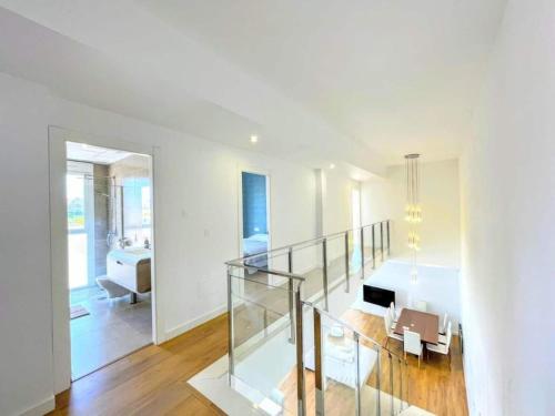 ein weißes Zimmer mit einer Glastreppe und einem Wohnzimmer in der Unterkunft Villa Olivo Gran Alacant by Villas&You in Gran Alacant