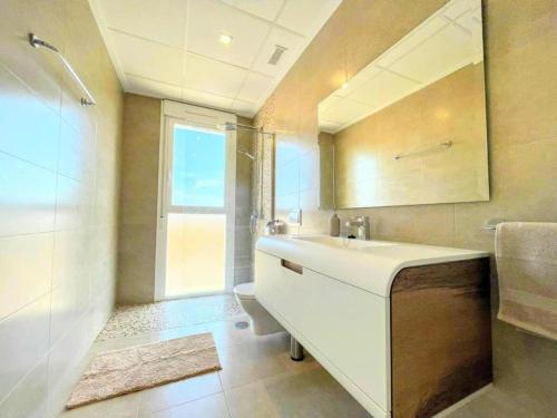 ein Badezimmer mit einem Waschbecken, einem WC und einem Spiegel in der Unterkunft Villa Olivo Gran Alacant by Villas&You in Gran Alacant