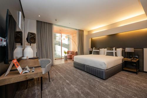 a large hotel room with a bed and a desk at The Capital 15 on Orange Hotel & Spa in Cape Town
