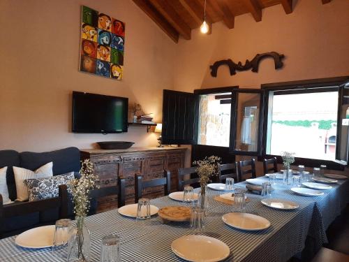comedor con mesa con sillas y TV en Apartamentos Rurales "La Escapada", en Argüero