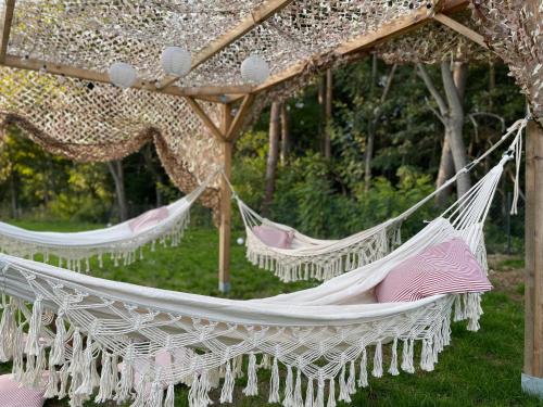 two white hammocks hanging from a pergola at beGLAMP - Glamping nad Zalewem Próba in Brzeźnio