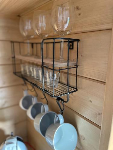 a rack of cups and wine glasses on a wall at beGLAMP - Glamping nad Zalewem Próba in Brzeźnio