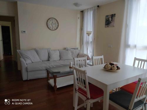 sala de estar con mesa y sofá blanco en Precioso apartamento Campo Golf, en Huesca