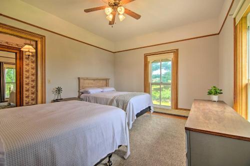 a bedroom with two beds and a ceiling fan at Spacious Farmhouse on 200 Acres Along the River in Edgerton