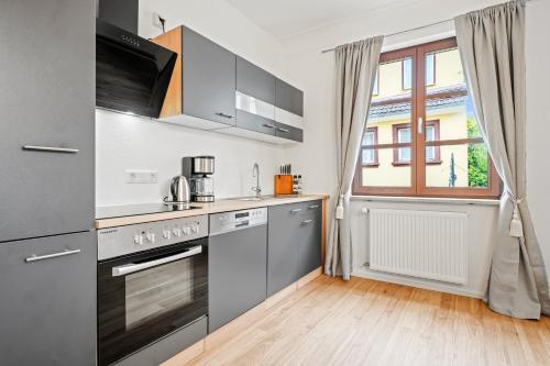 a kitchen with stainless steel appliances and a window at Residenz zu Montfort - Apartment Schlossblick in Tettnang