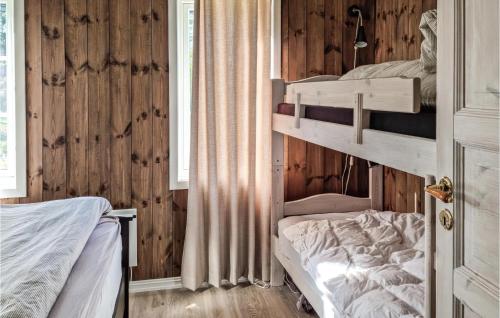 two bunk beds in a room with wooden walls at Stunning Home In Fossdal With Jacuzzi, 4 Bedrooms And Wifi in Fossdal