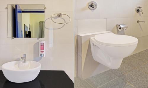 a bathroom with a white toilet and a sink at Blue Door in Morjim