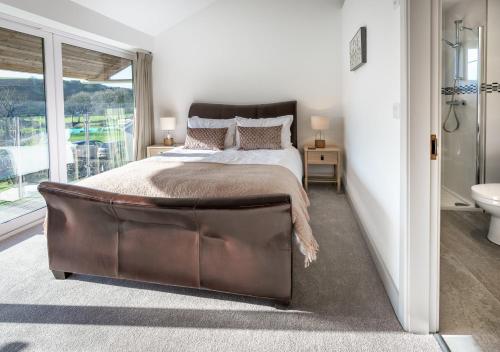 una camera con un grande letto e una grande finestra di Ty Nant a Dinas