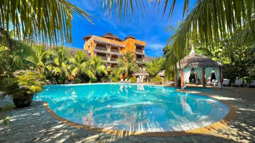 a swimming pool in front of a resort at Coco Grove Beach Resort, Siquijor Island in Siquijor