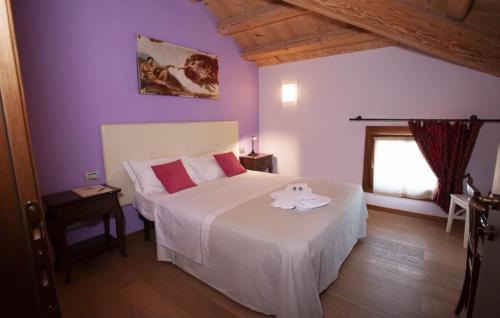 a bedroom with a large white bed with purple walls at Villa Maria Luigia in San Biagio di Callalta