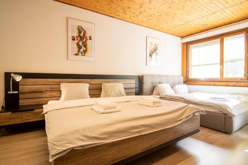 1 Schlafzimmer mit 2 Betten und einem Fenster in der Unterkunft Miraflor Betty by Arosa Holiday in Arosa