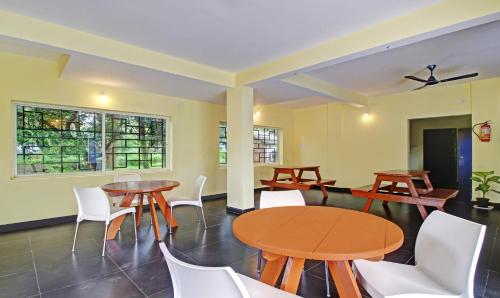 une salle à manger avec des tables et des chaises blanches dans l'établissement Blue Door, à Morjim
